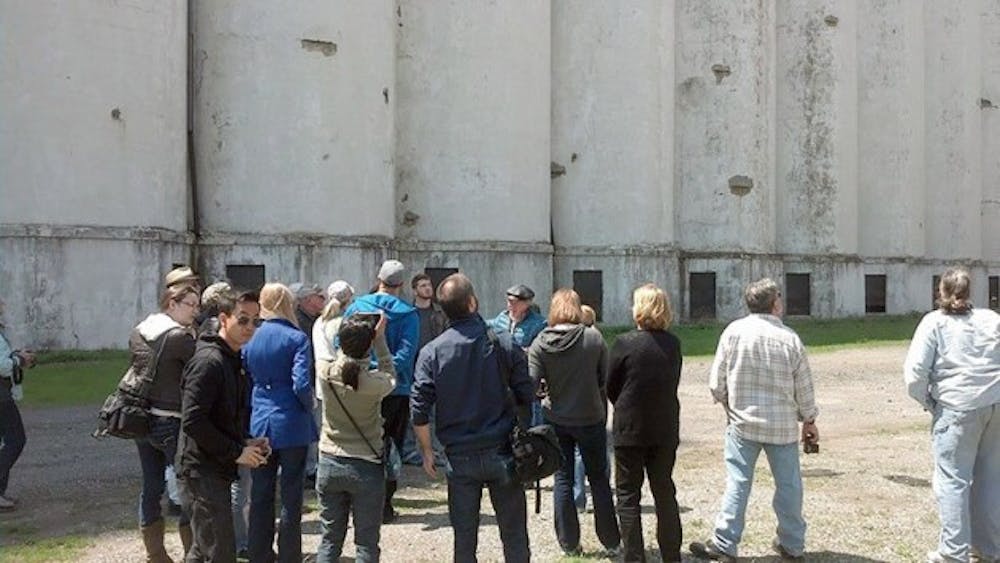 A tour group for Explore Buffalo stands looking up at one of the grain elevators that dots Buffalo&rsquo;s skyline. By touring both the hidden and obvious parts of Buffalo, Explore Buffalo tours give a unique perspective on the city&rsquo;s past and present.&nbsp;Courtesy of Explore Buffalo