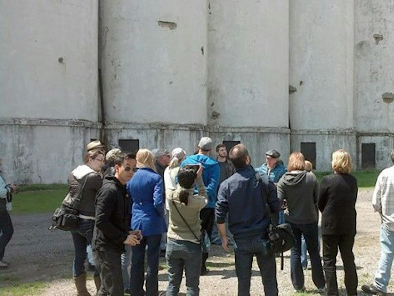 A tour group for Explore Buffalo stands looking up at one of the grain elevators that dots Buffalo&rsquo;s skyline. By touring both the hidden and obvious parts of Buffalo, Explore Buffalo tours give a unique perspective on the city&rsquo;s past and present.&nbsp;Courtesy of Explore Buffalo