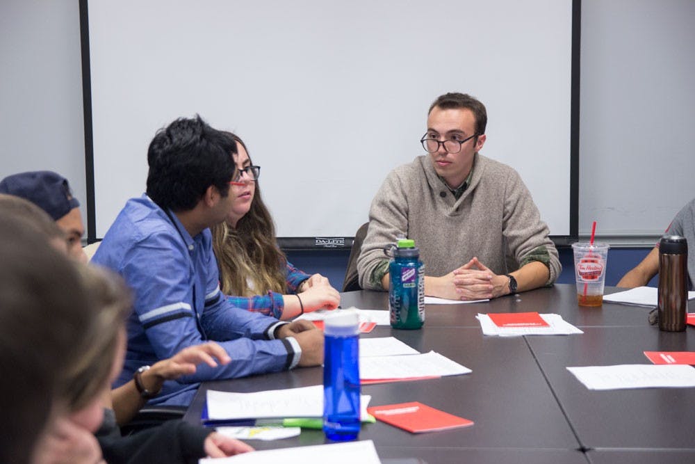 <p>Dillon Smith (far right) speaks with other senators during Monday night's Student Association senate meeting. Smith was elected senate chair Monday night. He was originally elected the chair two weeks ago, but that election was deemed invalid by SA's own attorney. </p>