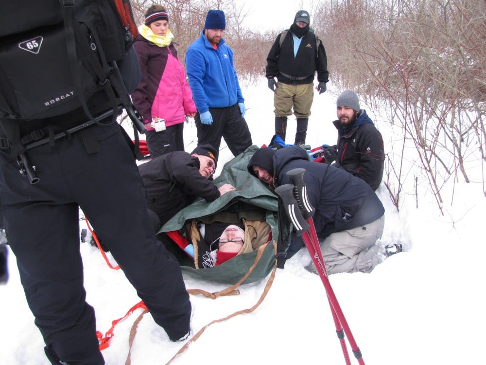 <p>Vanessa Dwyer, a sophomore environmental geosciences major; Andrew Harp, a PhD student in geology; Chris Portor of CDS Outdoor Inc.; and Kevin Sauta, a senior environmental geosciences major look on as Mike Mazuitowski and Max Bass, a junior social sciences interdisciplinary major participate in a drill on an Outdoor Pursuits trip in which they evacuate a "victim."</p>