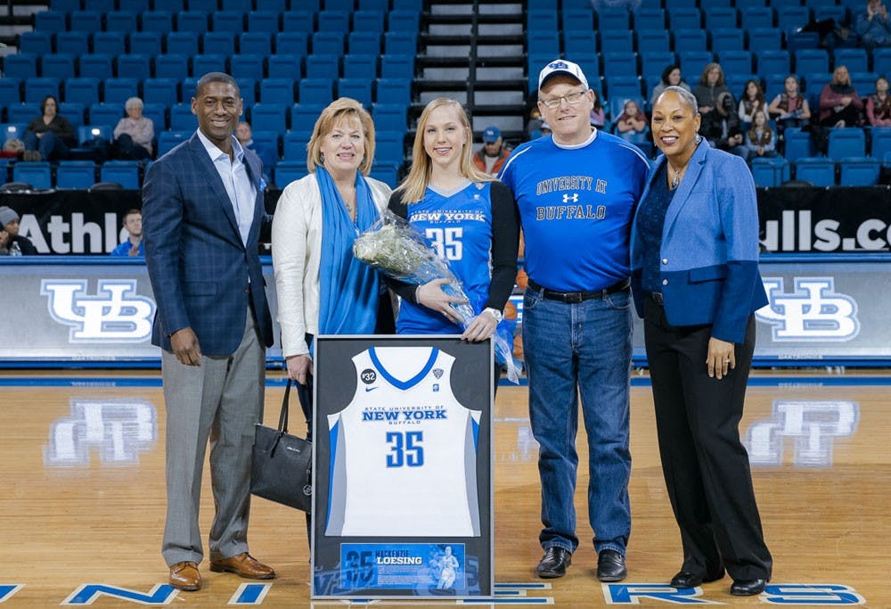 <p>Former women's&nbsp;basketball player Mackenzie Loesing (center)&nbsp;stands on the court with her family, head coach Felisha Legette-Jack (right)&nbsp;and Athletic Director Allen Greene (left). Loesing was awarded with her jersey on Senior Day, after an ankle injury ended her career last April.</p>