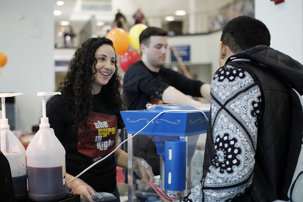 <p>Carly Kreitzberg (front), a senior communication and psychology major, and James Roy (back), a senior communication major, serve snow cones and cotton candy to students as part of the "Type is Right" event aims to get more students to become organ donors.</p>