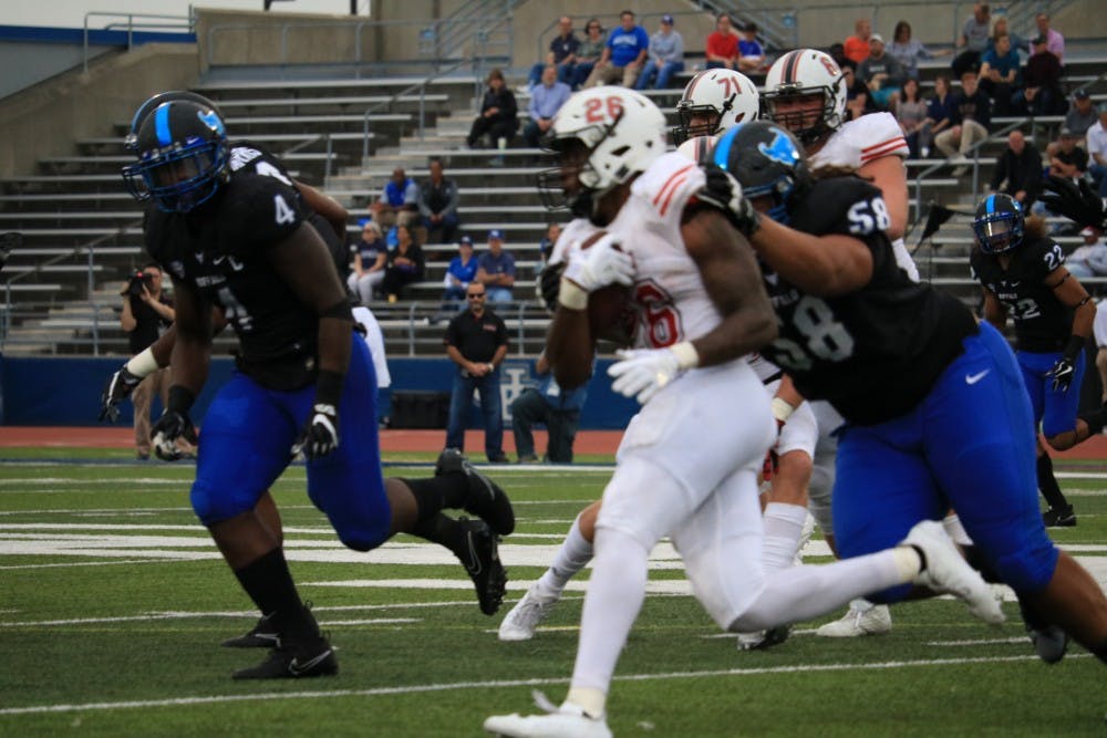 Defensive lineman Chris Ford pushes for the tackle against the running back. Ford is one of three former Bulls to be invited to NFL mini camps in the passing weeks.