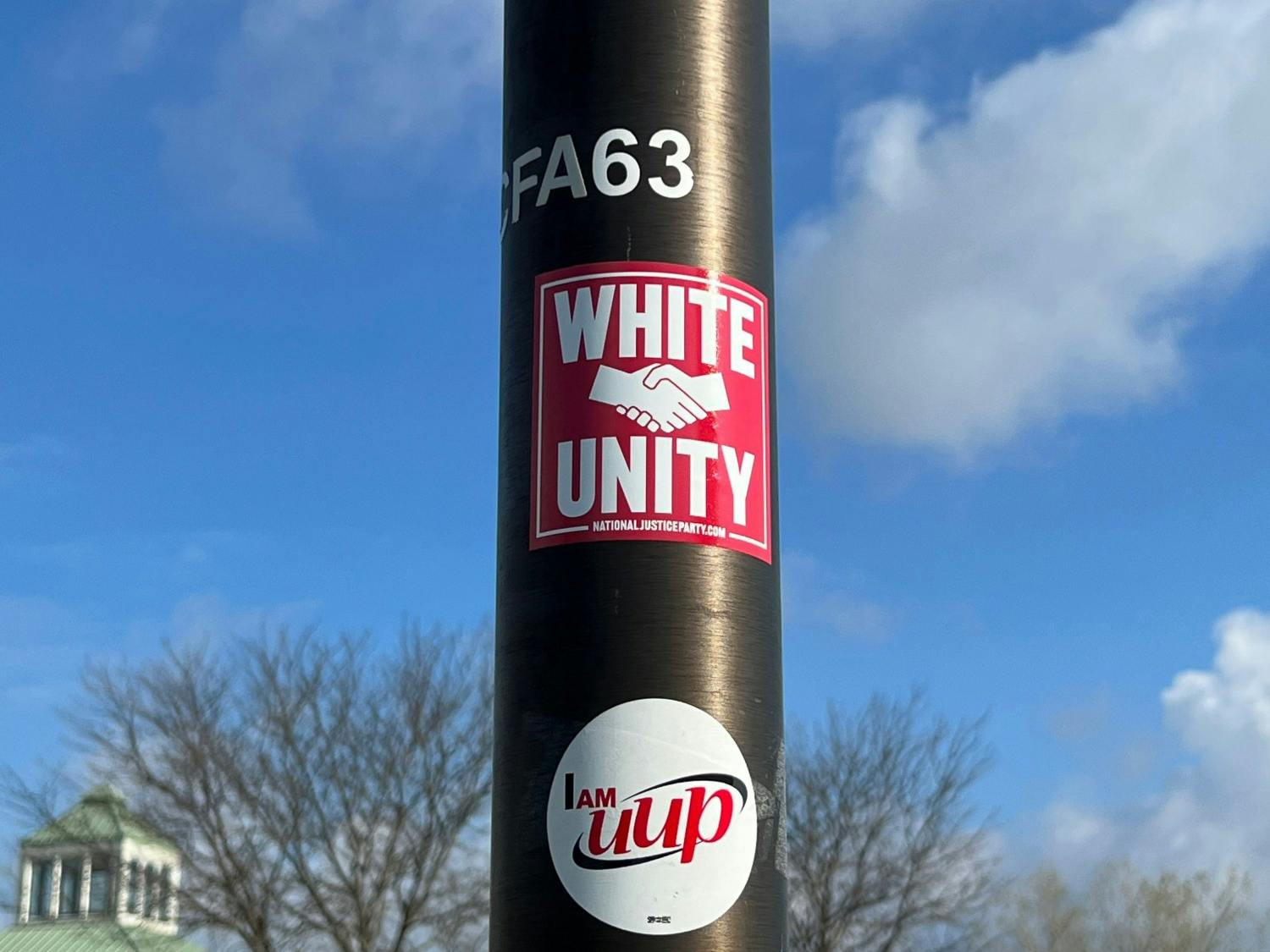 A sticker with the message “white unity” on a lamppost near The Commons.