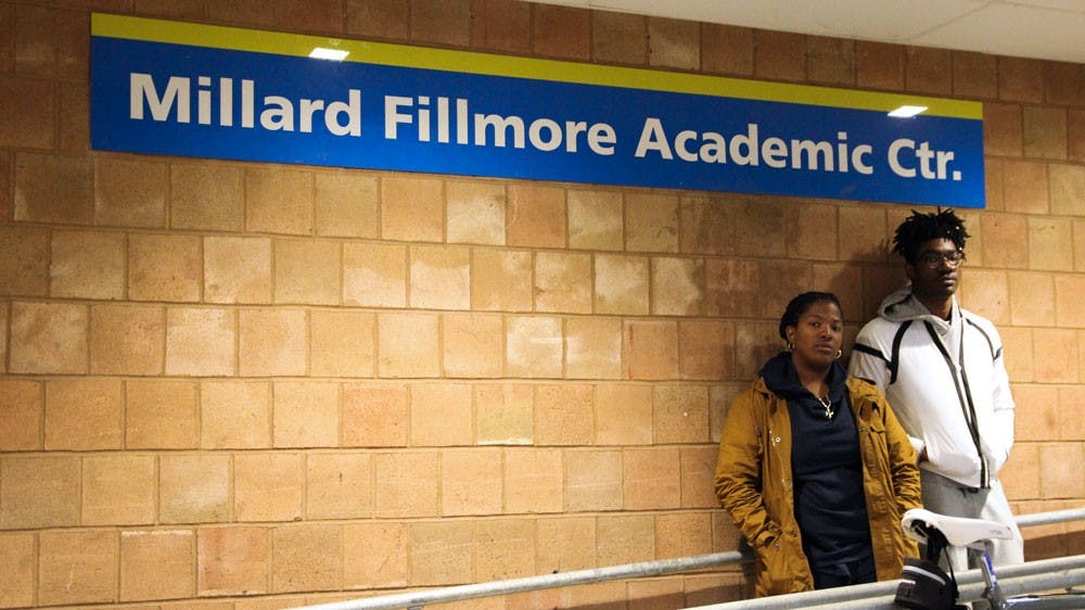 <p>Deidree Golbourne (left) and Tavaine Whyte (right) stand outside of the Millard Fillmore Academic Center. The two question how UB represents Fillmore on campus and say more needs to be done to educate students of his history.</p>