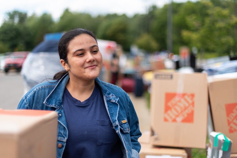 <p>Sophomore Daphne Da Silva amongst piles of boxes.</p>