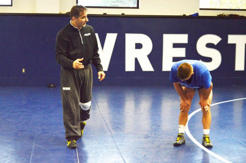 <p>Head coach John Stutzman overlooks a Bulls wrestler during practice as Buffalo prepares for the 2015-16 season.</p>