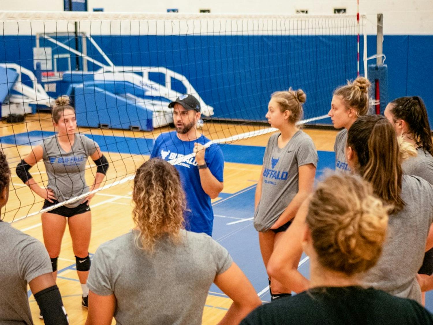 Coach Smith instructing the volleyball team during a practice at Alumni Arena.