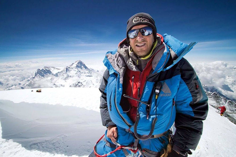 <p>Dave Hahn stands on the summit of Mount Everest. Hahn has summited Everest more times than any non-Nepal native in world history.</p>