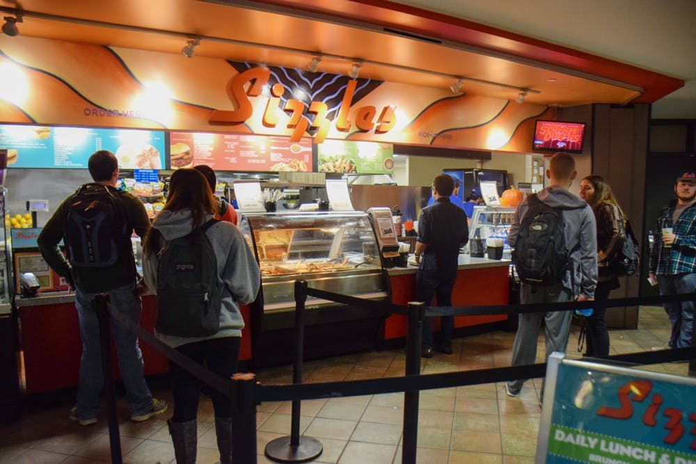<p>UB students wait in line to order from Sizzles and Hubie’s during late night meal plan hours. Hubie’s and Sizzles are the only options available in the Ellicott Complex for late night meal plan hours, both of which specialize in fast food items like pancakes, pizza and burgers.</p>
