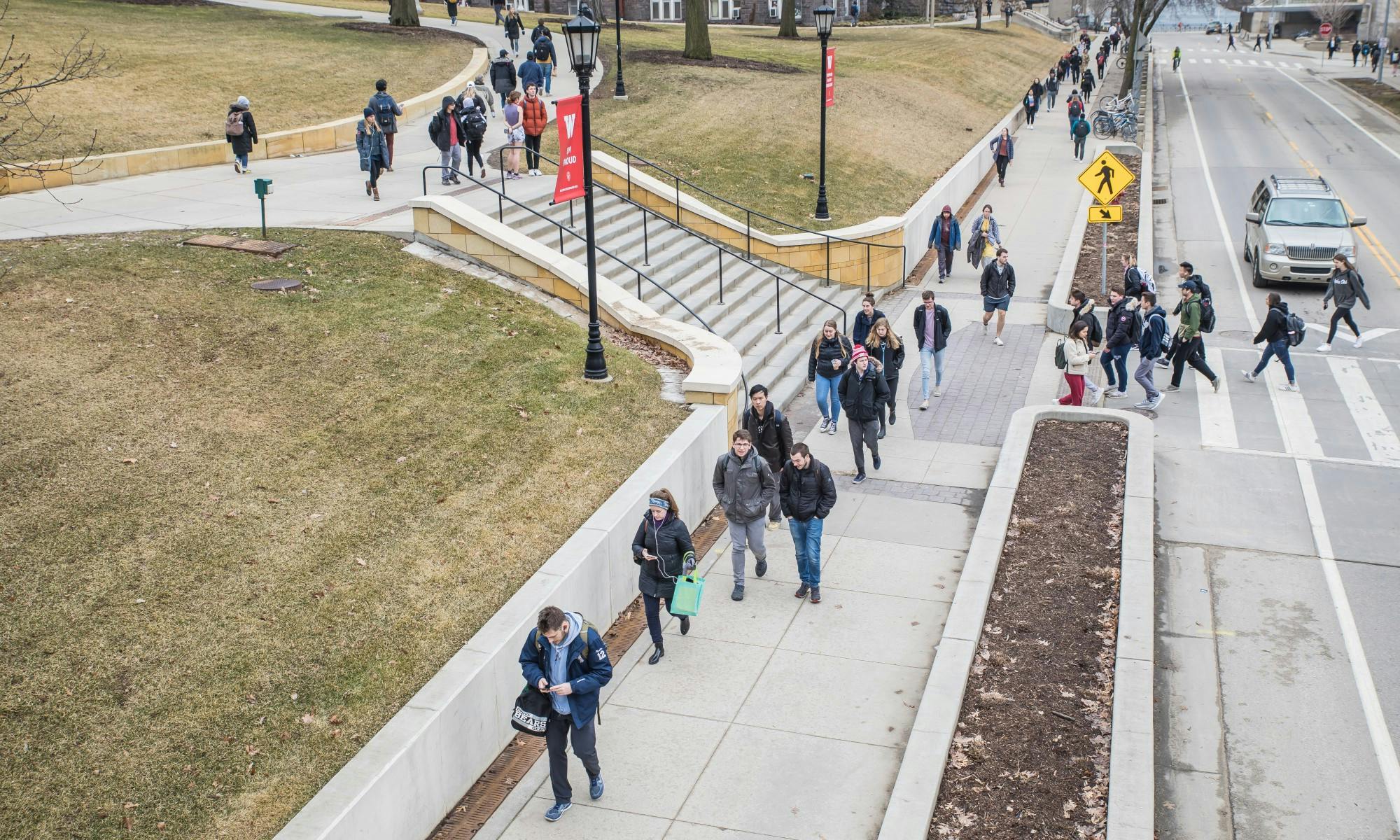 Photo of people walking across the intersection to Bascom Hill pre-Covid.