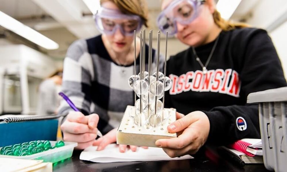 Two UW-Madison students participate in a science experiment in their chemistry class.