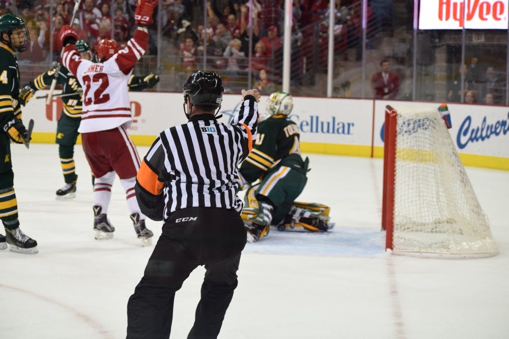 Max Zimmer throws his hands in the air after the Badgers score Saturday night.&nbsp;
