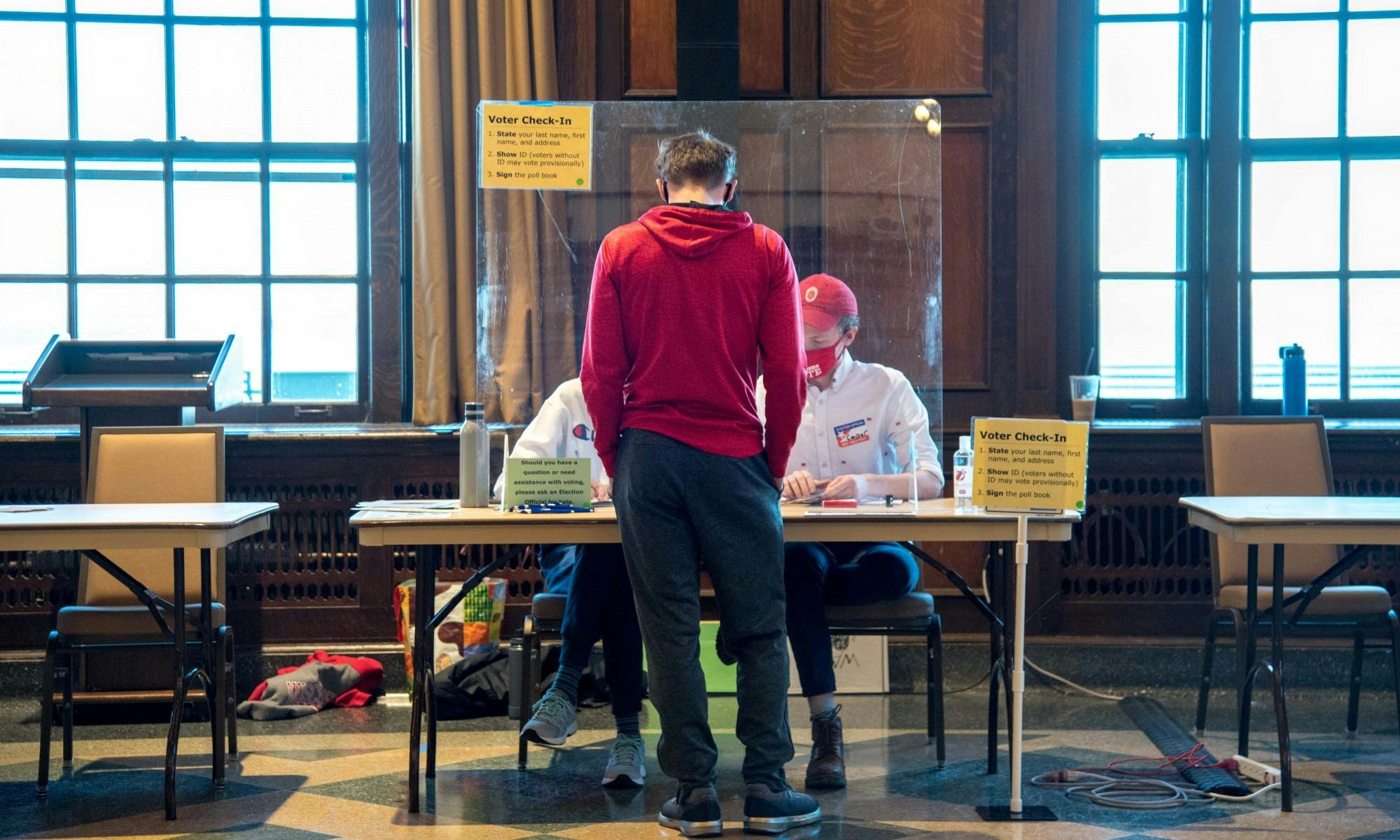 Photo of student getting a ballot to vote.