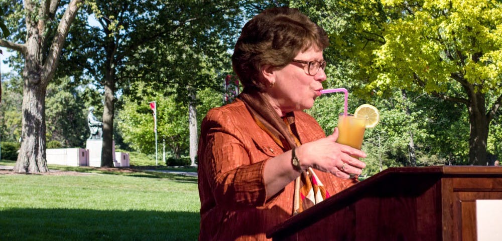 UW-Madison Chancellor Rebecca Blank sips lemonade as she sells baked goods on Bascom Hill.