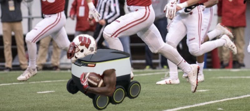 Starship Jonathan Taylor carries the ball down the field during a UW Athletics test of Starship Robots in place of football players.