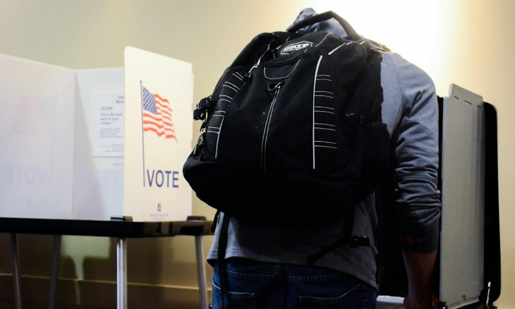 Students, led by UW basketball player Vitto Brown, cast their ballots Monday as early voting began on campus.