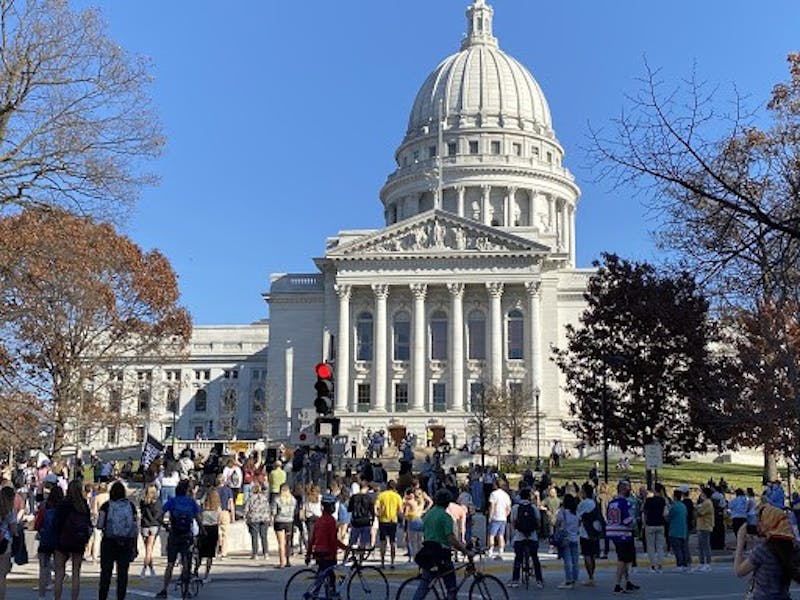 Students, residents and activists alike congregated outside of the State Street corner of the Wisconsin State Capitol Building in what turned out to be a massive gathering.