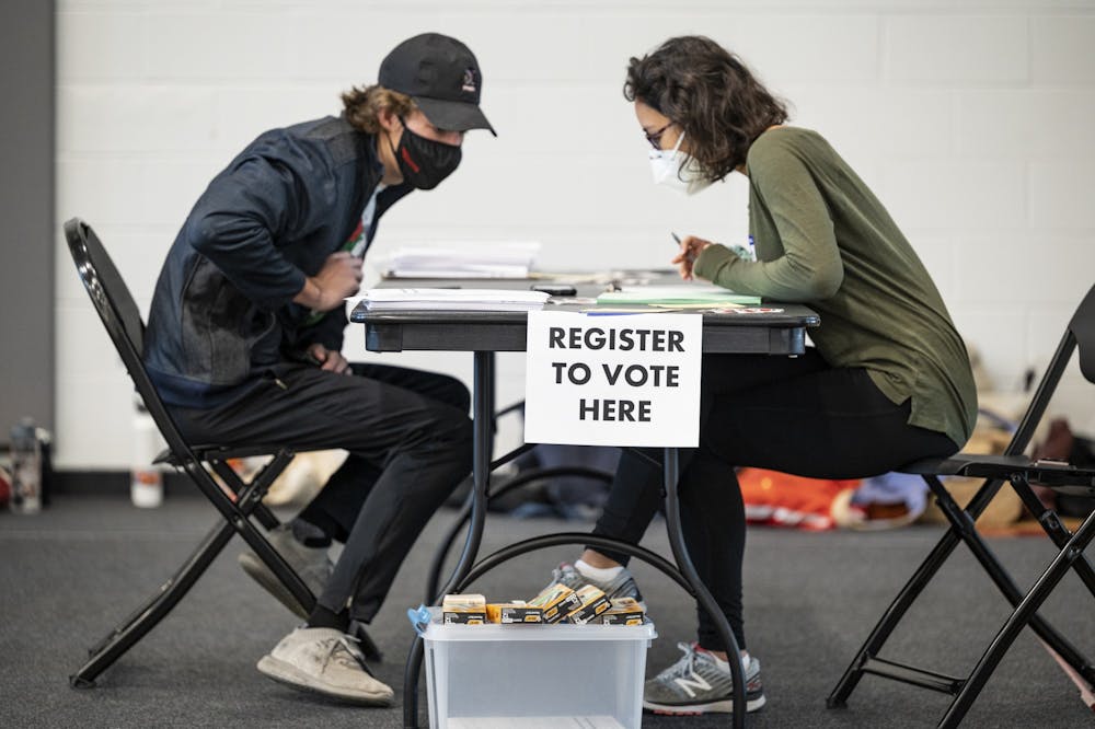 A UW student registers to vote before casting their ballot at the Nicholas Recreation Center polling station.