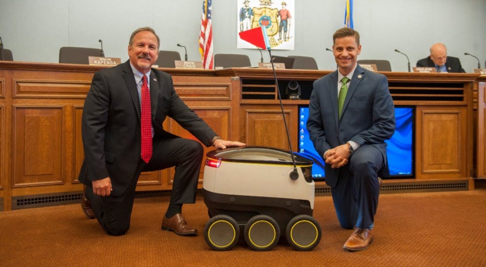 State Rep. Mike Kuglitsch, R-New Berlin, (left) and state Sen. Chris Kapenga, R-Delafield, (right) with a Starship robot after the technology company gave a demo during a committee hearing.&nbsp;