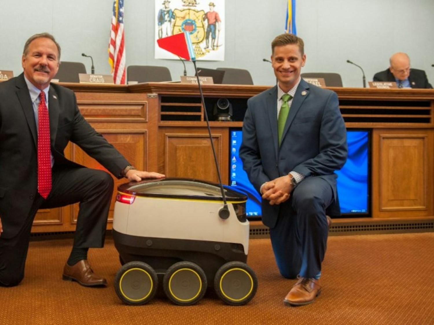 State Rep. Mike Kuglitsch, R-New Berlin, (left) and state Sen. Chris Kapenga, R-Delafield, (right) with a Starship robot after the technology company gave a demo during a committee hearing.&nbsp;