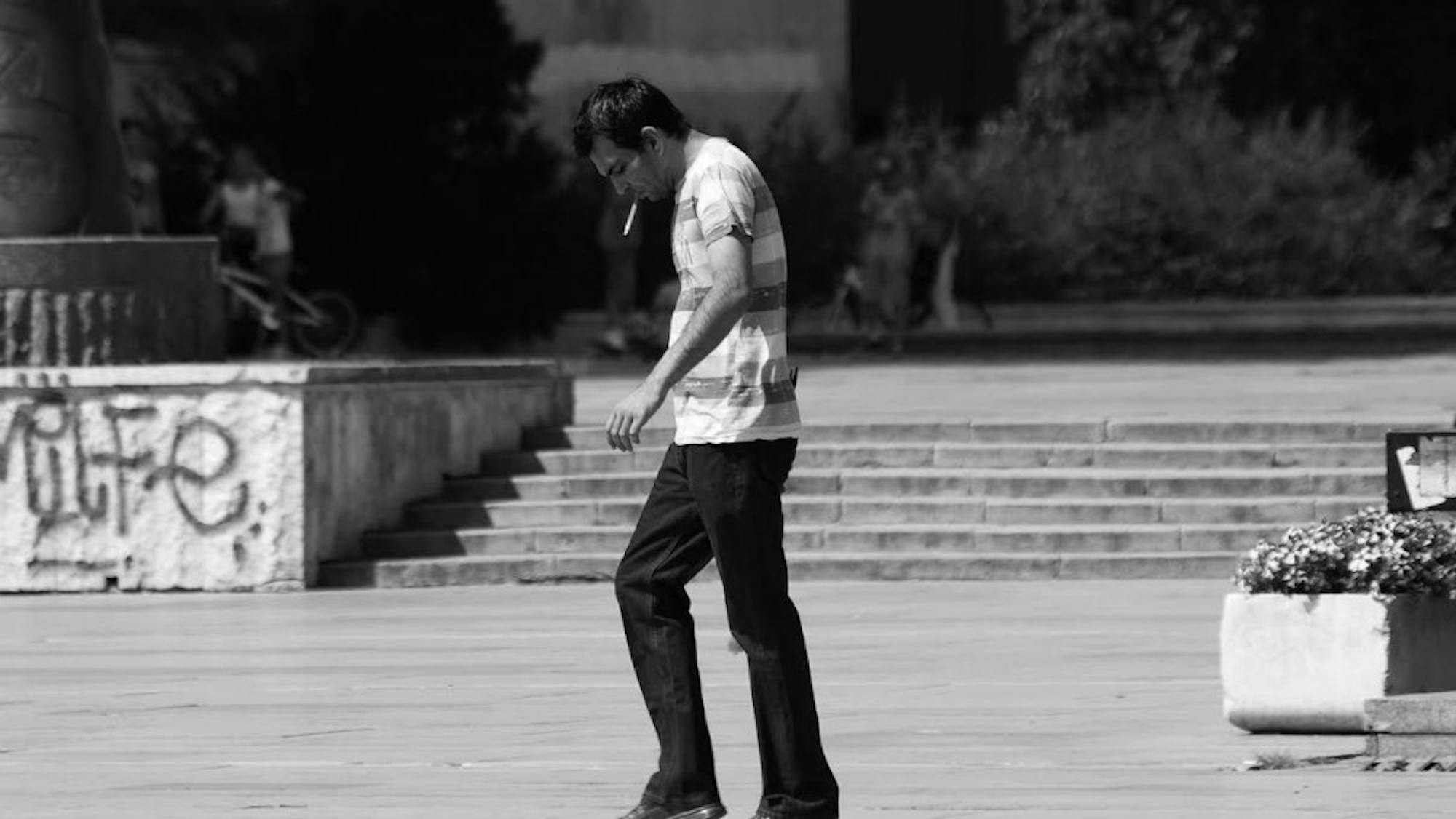 UW student seen smoking a cigarette in a designated smoking area.