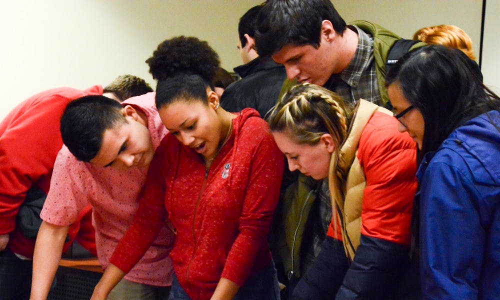 Associated Students of Madison candidates&nbsp;for Student Council huddle around election results at a press conference Wednesday night.&nbsp;