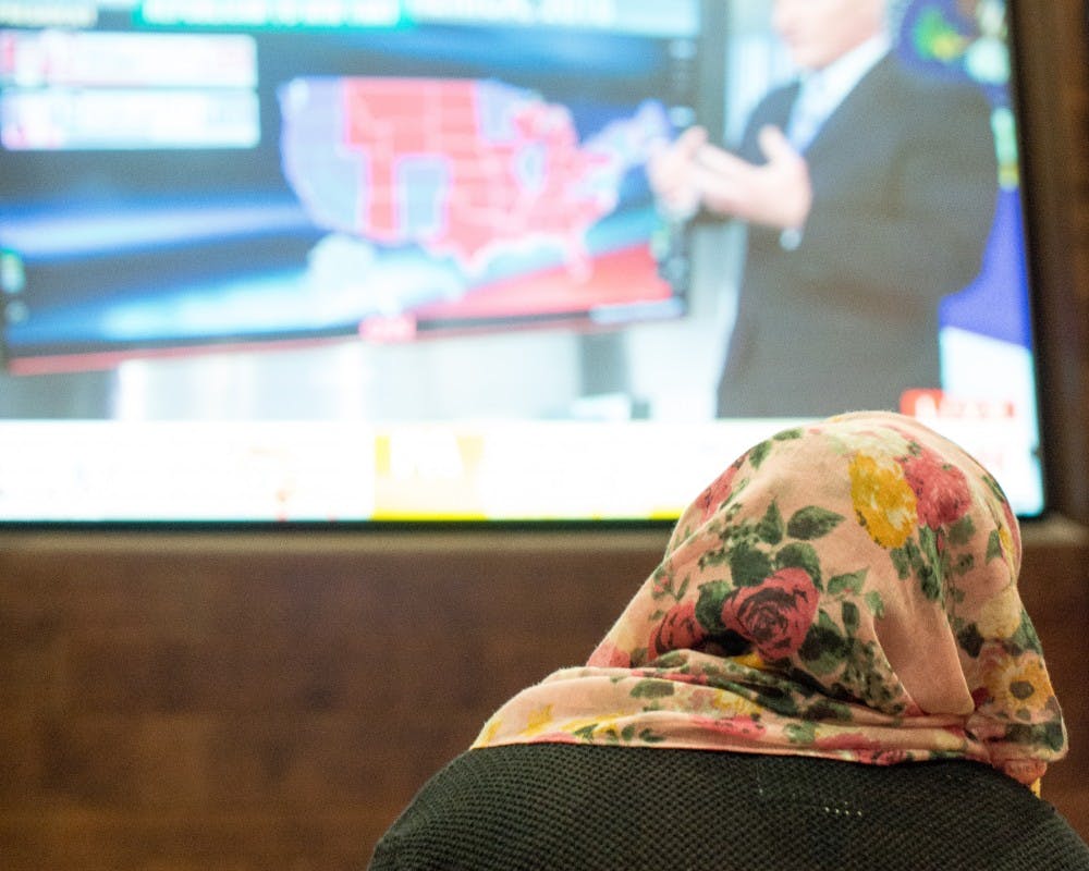 A hijab-clad student watches the presidential election results at Union South last November. Since the election, President Donald Trump signed an executive order to limit immigration.