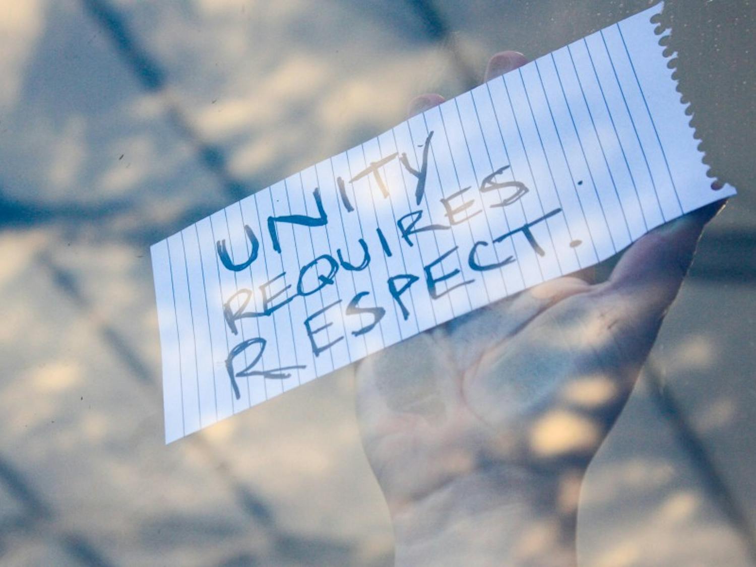 A protester holds a sign while occupying the media center Tuesday. Demonstrators walked out of the convention hall after Clinton secured the nomination.