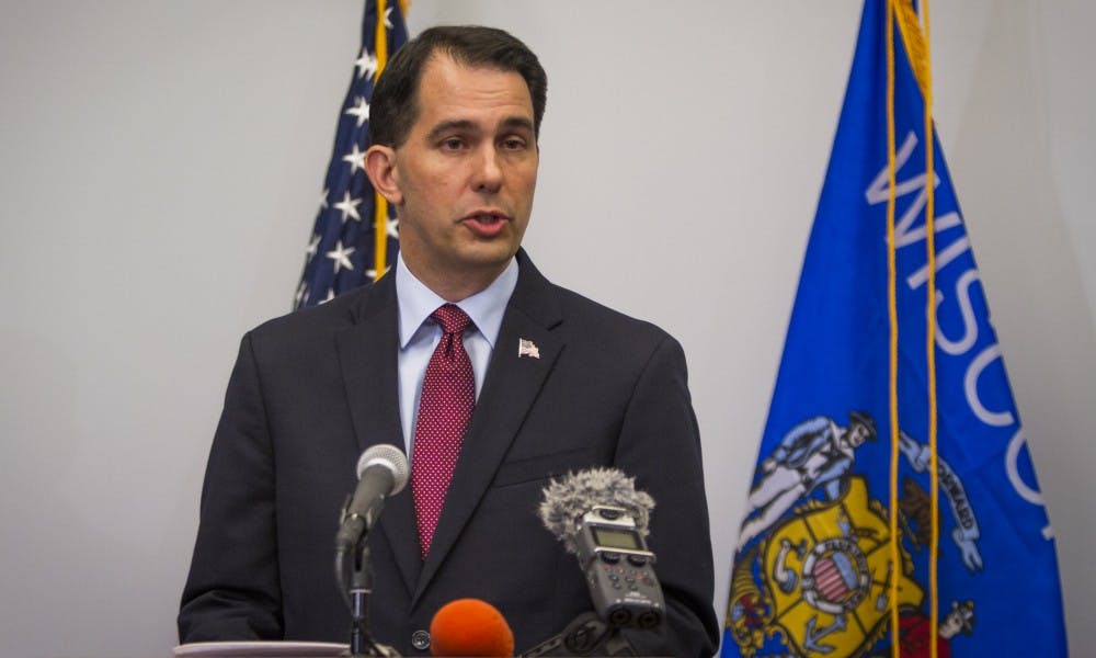 Gov. Scott Walker signed almost 60 bills into law Tuesday, including one making it easier for law enforcement to perform strip searches.