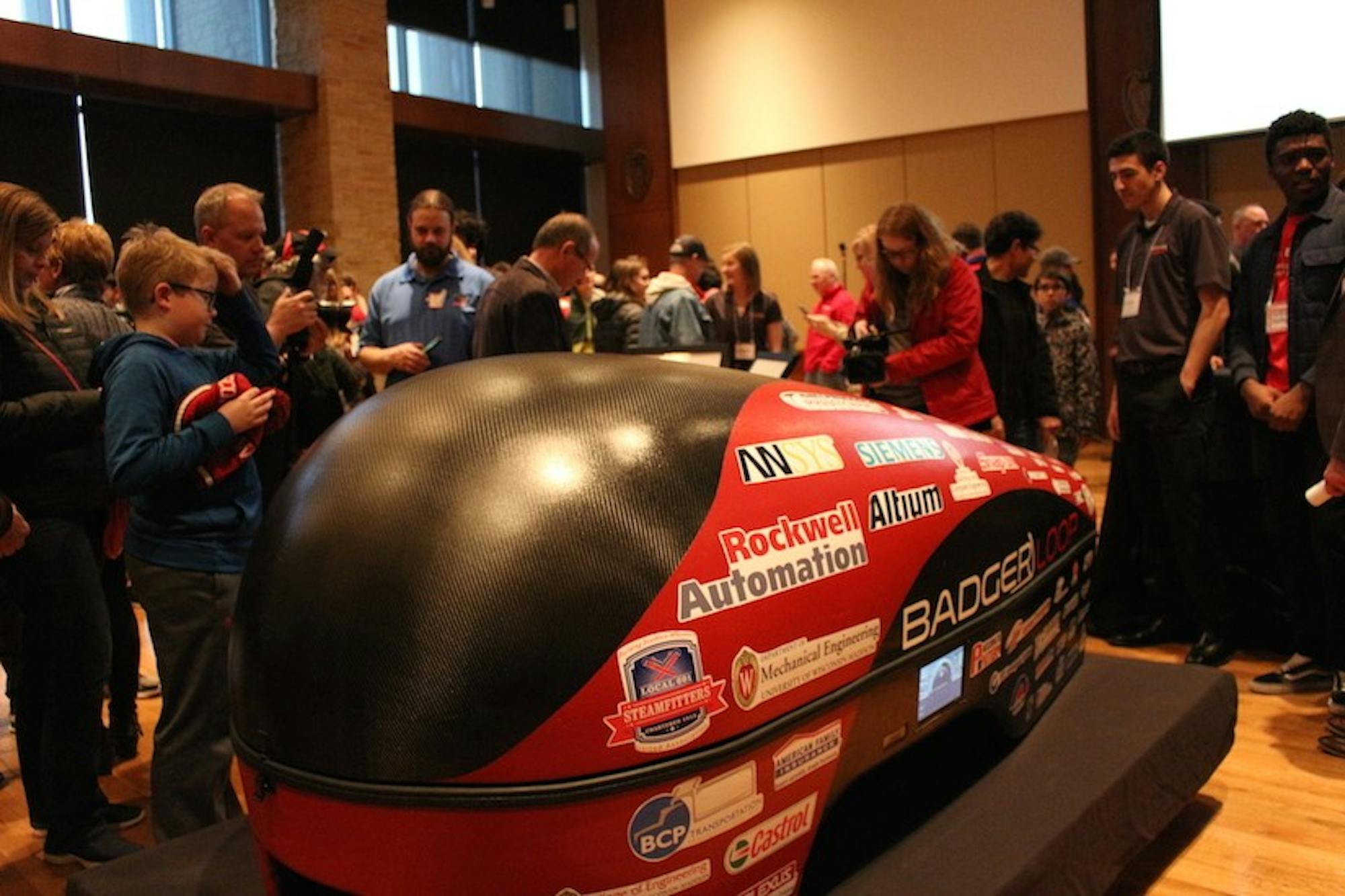 Attendees of all ages view Badgerloop’s newest Pod III, an electric-propulsion carbon fiber hyperloop pod.