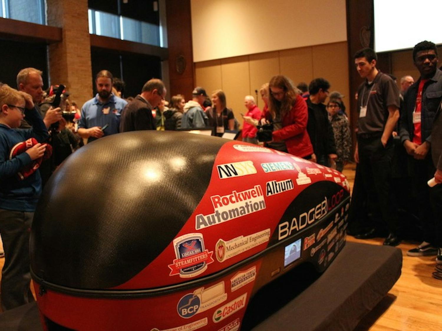 Attendees of all ages view Badgerloop’s newest Pod III, an electric-propulsion carbon fiber hyperloop pod.