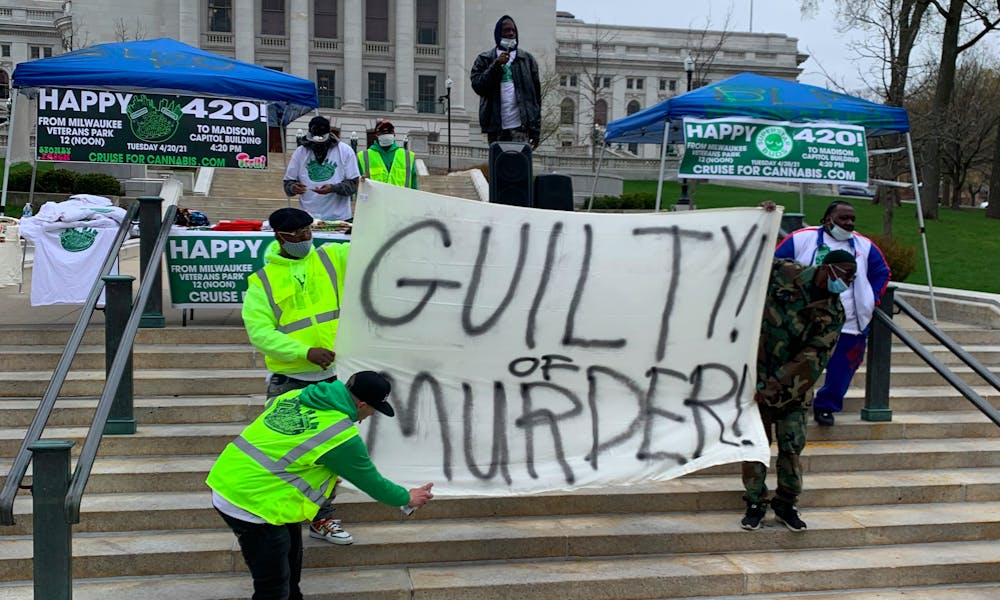 Photo of a group of men holding up a sign that says "Guilty of Murder" in reference to the Chauvin trial.