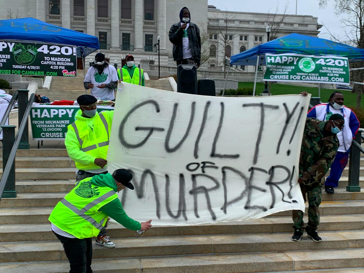 Photo of a group of men holding up a sign that says "Guilty of Murder" in reference to the Chauvin trial.