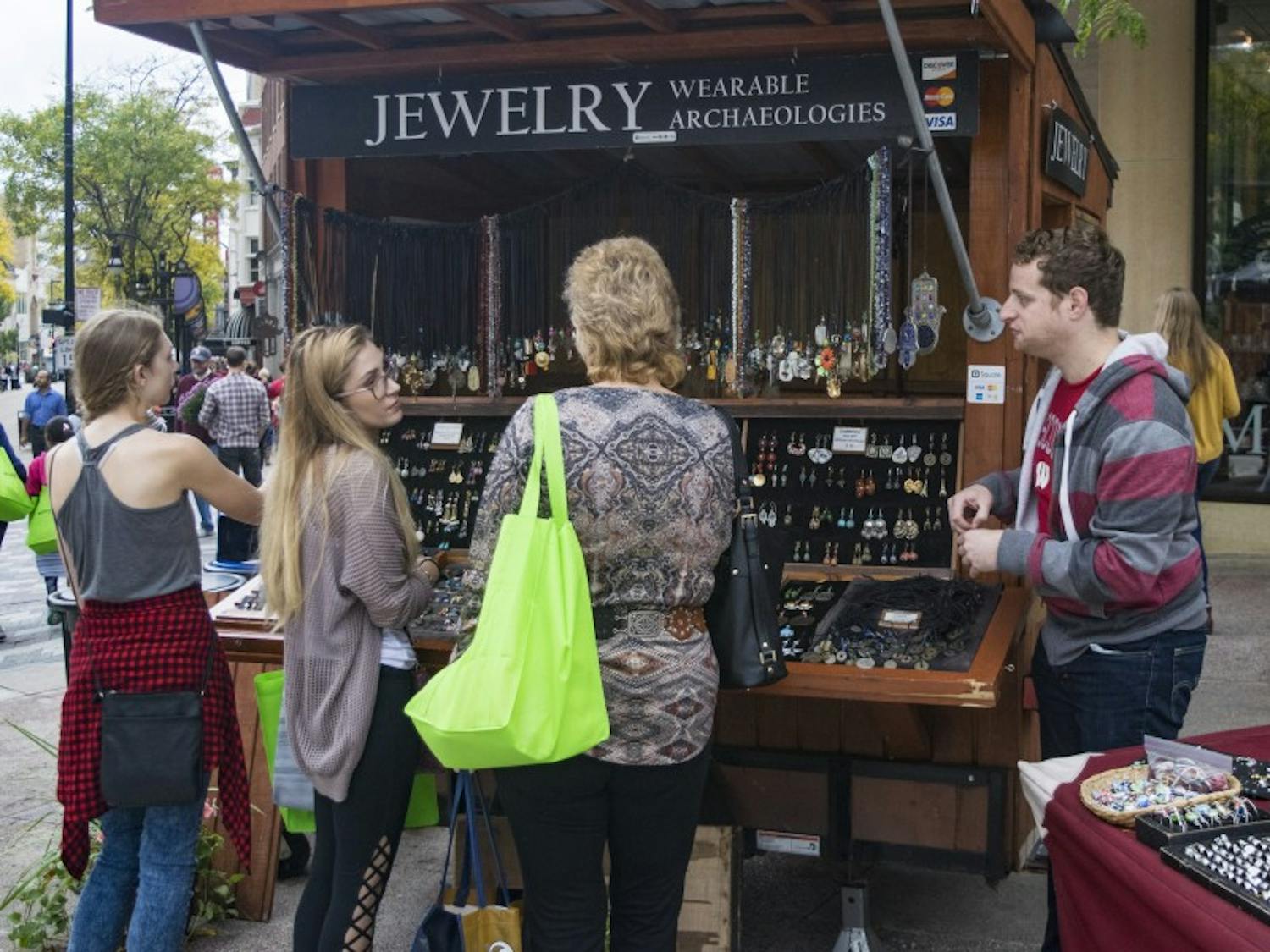 UW-Madison PhD student Jacob Hellman attempts to sell jewelry to customers at his stand Wearable Archaeologies, a job he said “doesn’t feel like a job” because of his love for it.