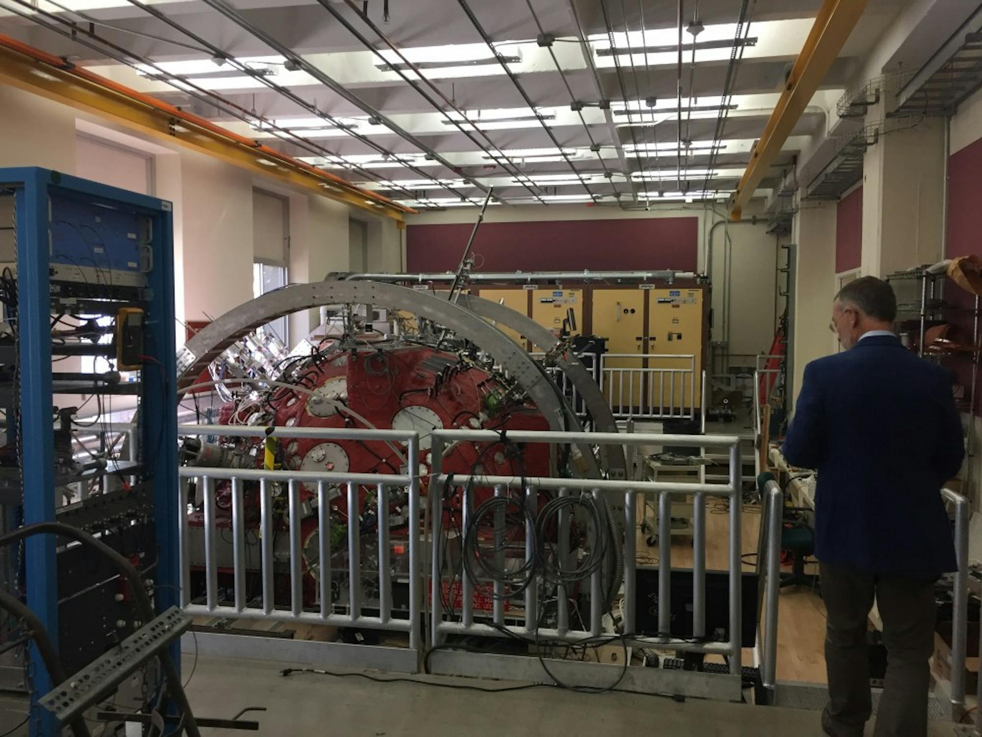 Cary Forest stands in front of the Big Red Plasma Ball, an important tool he uses to study plasma and solar flares.