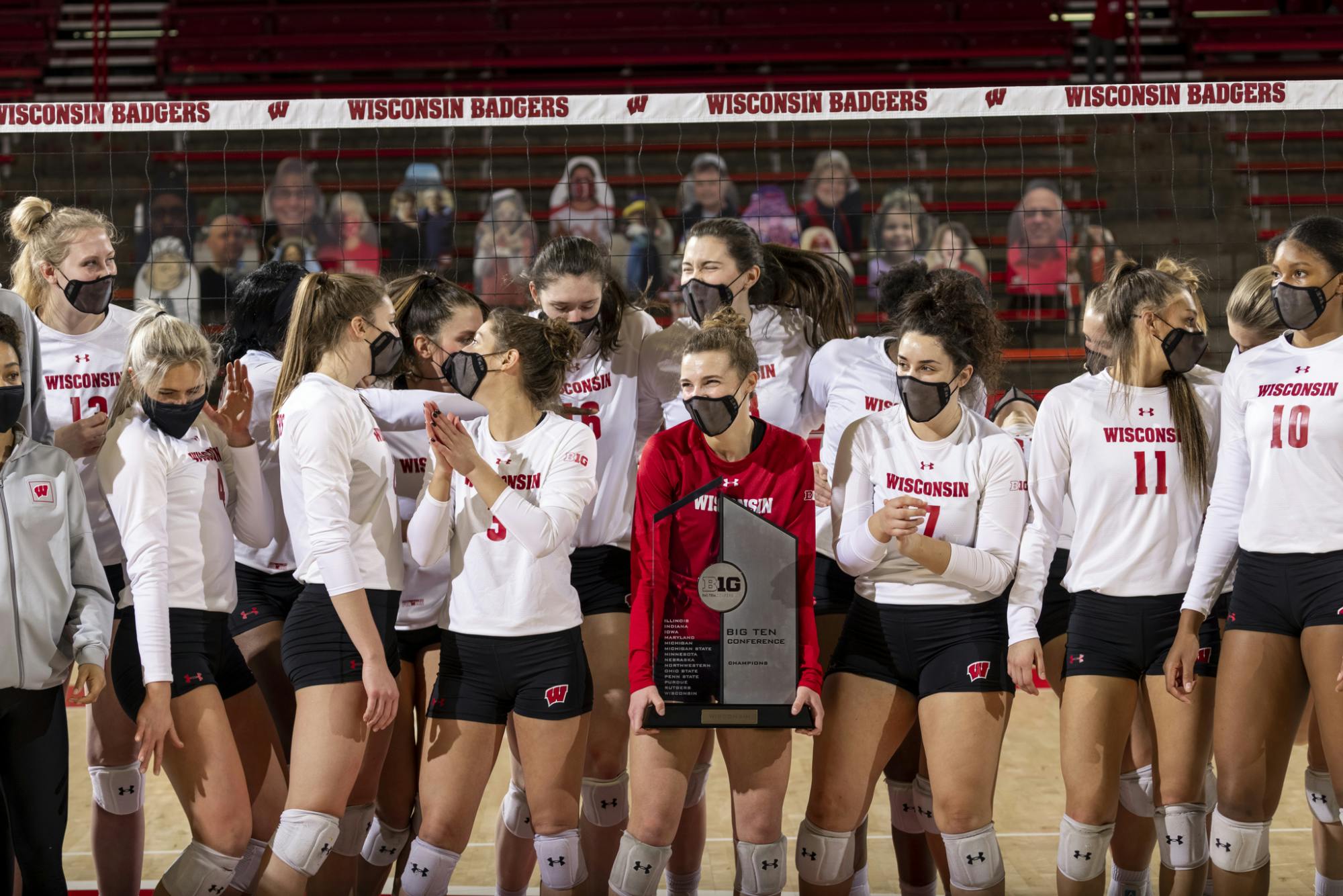 Photo of volleyball team holding Big Ten conference champions plaque.