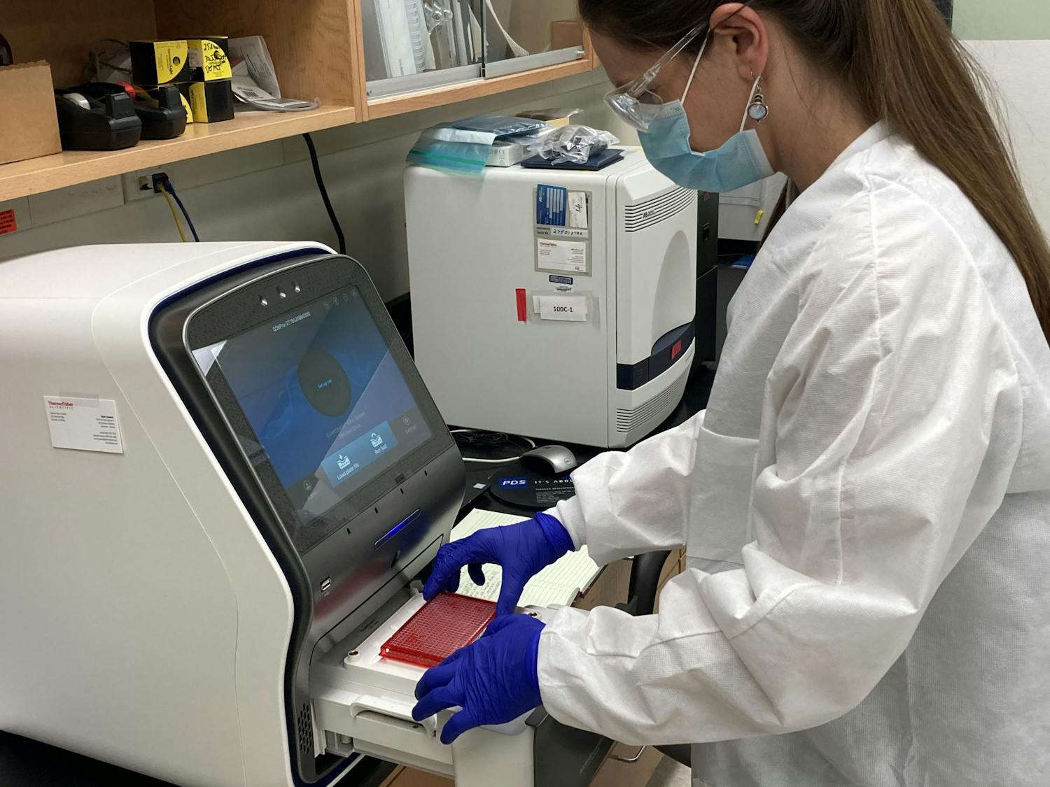 200914_dagmara antkiewicz places plate with samples into qPCR instrument for analysis .JPG
