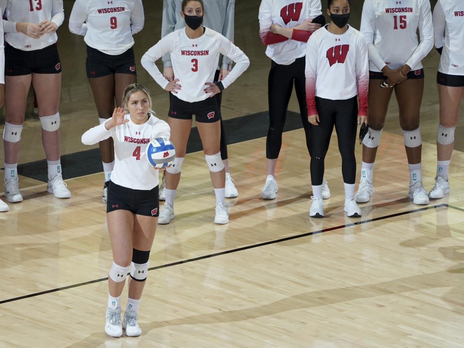 A Badger volleyball player getting ready to serve the ball.
