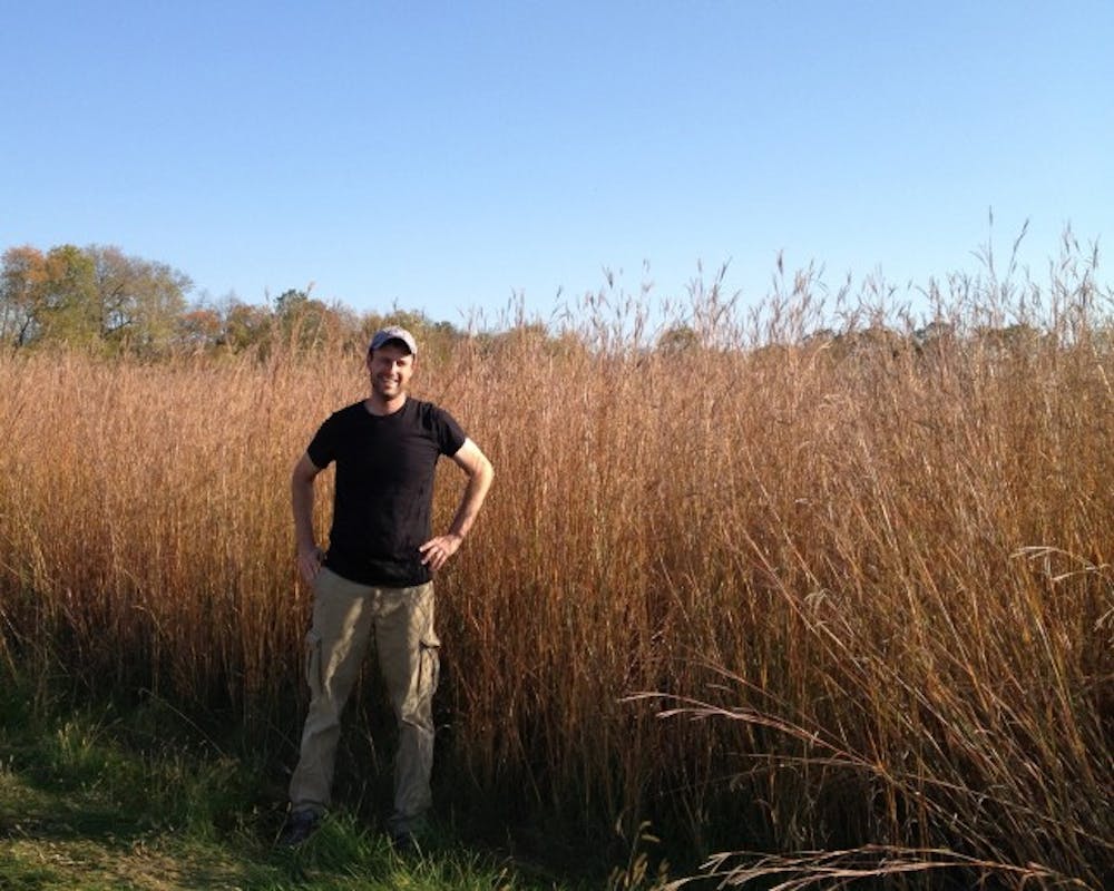 Lead author of the report Peter Blank stands in front of a grassland of bioenergy crops.&nbsp;