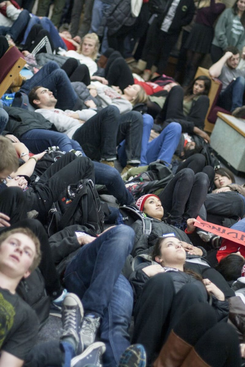 Protesters lay on the ground around students studying for finals for 20 minutes before concluding the demonstration outside the doors of the library.