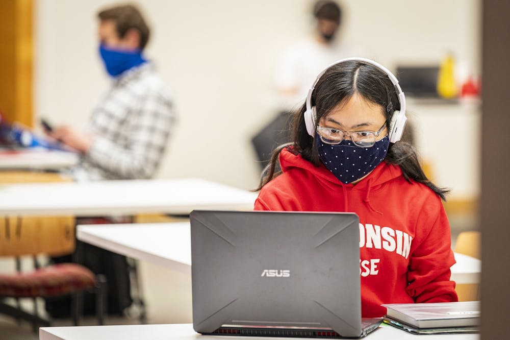 A student wears a mask as part of the Safer Badgers protocol while studying inside of Engineering Hall.