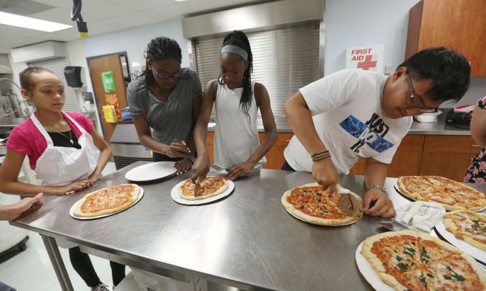 UW-Madison fifth-year student Donale Richards instructed a science curriculum for high school juniors and seniors enrolled in the PEOPLE Program during the summer of 2016 and worked with the group to market their own pizza.