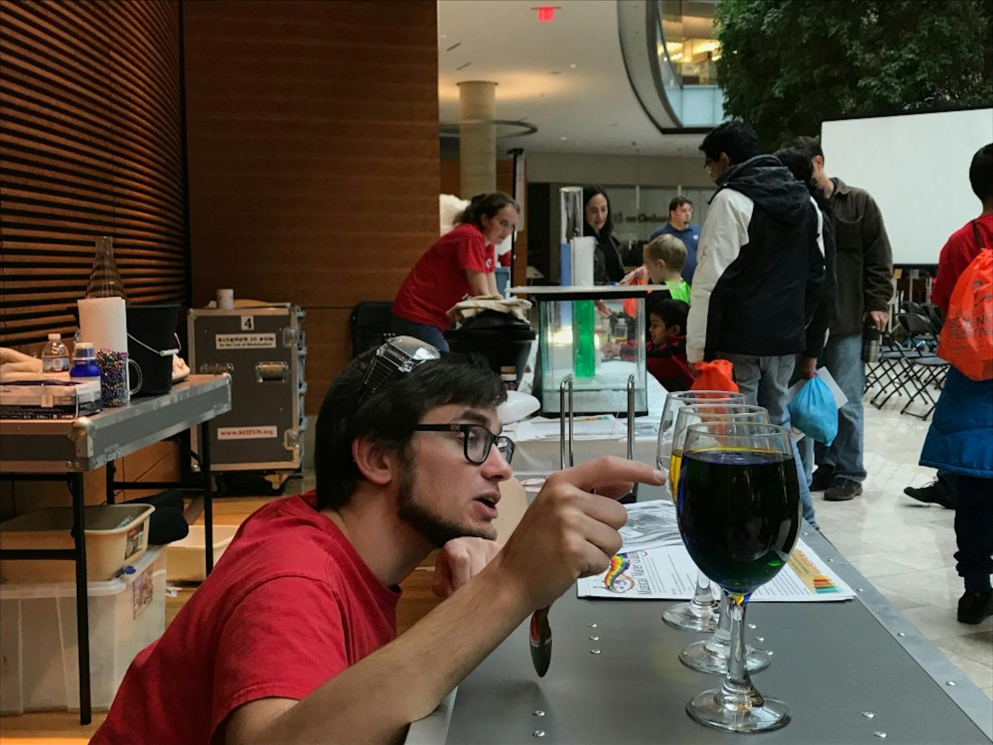 A volunteer explains the differences in pitch that occur in glasses with different amounts of liquid in them. Photo by Tyler Fox.&nbsp;