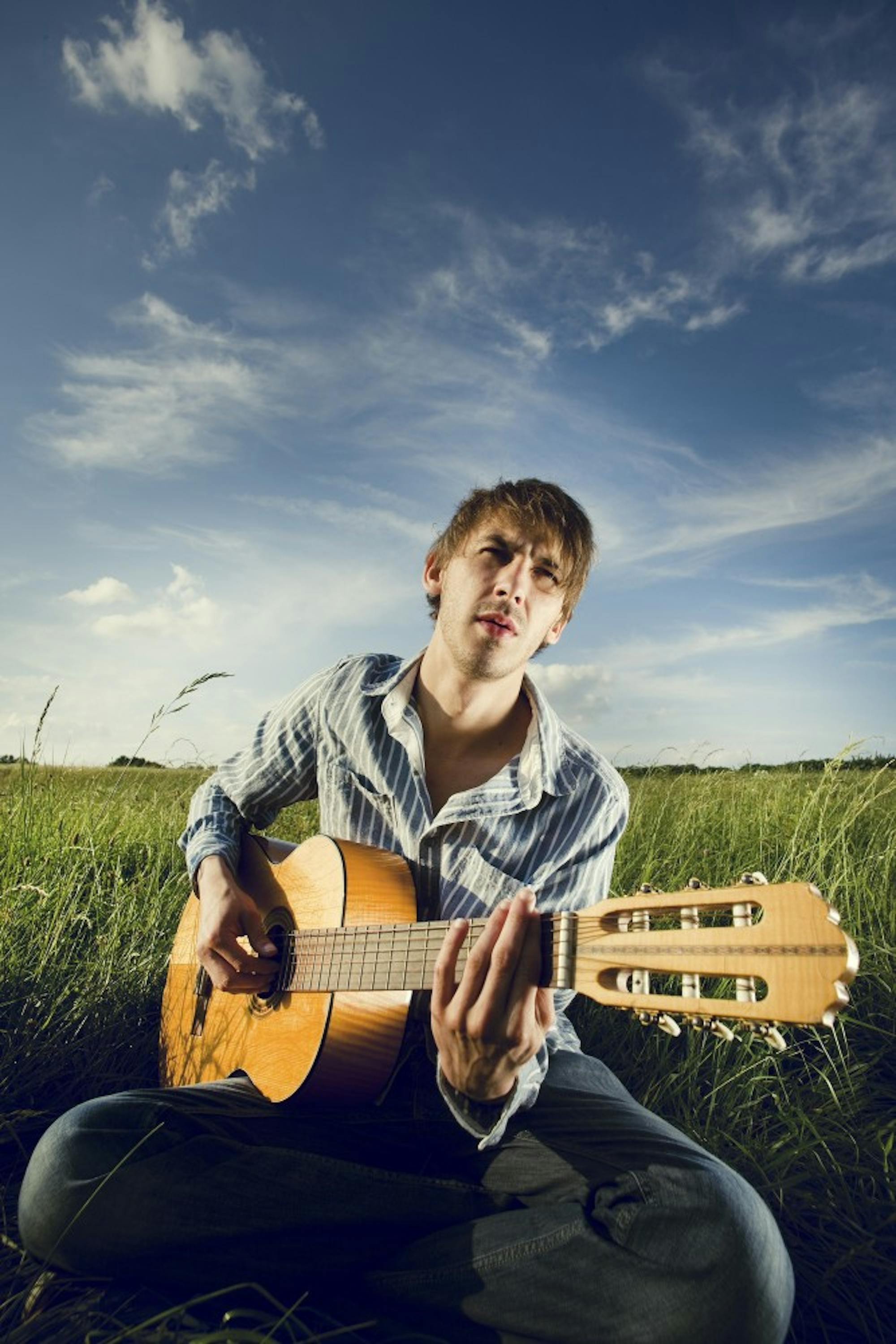 Hugh Jass strums a forlorn chord from “Wonderwall” in a lonely field.