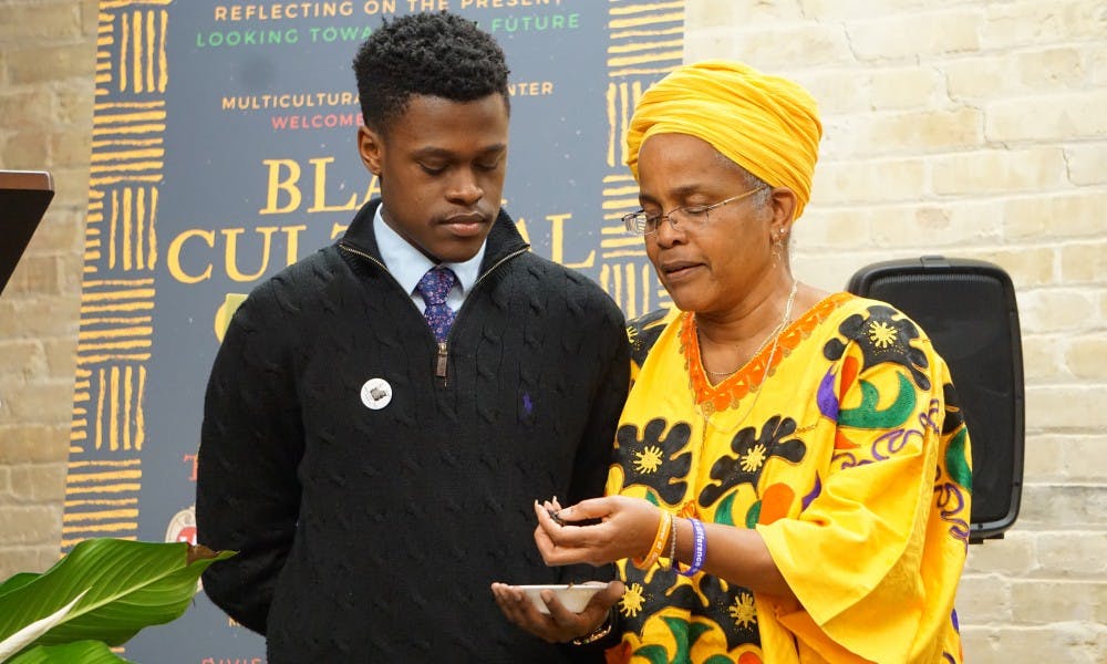 UW-Madison’s Black Student Union President Marquise Mays and Program Development and Assessment Specialist in the Division of Student Life Hazel Symonette spread tobacco around the new Black Cultural Center space during a dedication and libation ceremony.
