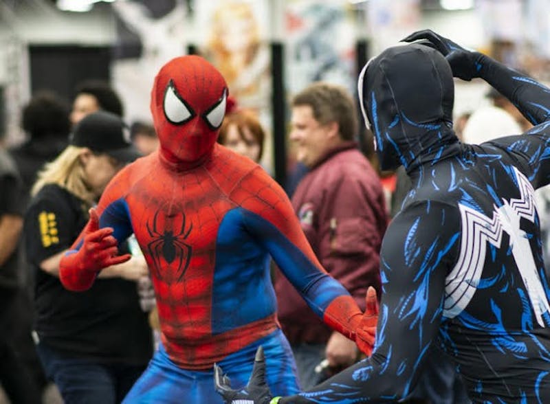 Two convention goers dressed as Marvel's Spider-Man and Venom do battle at Wizard World Comic Con.