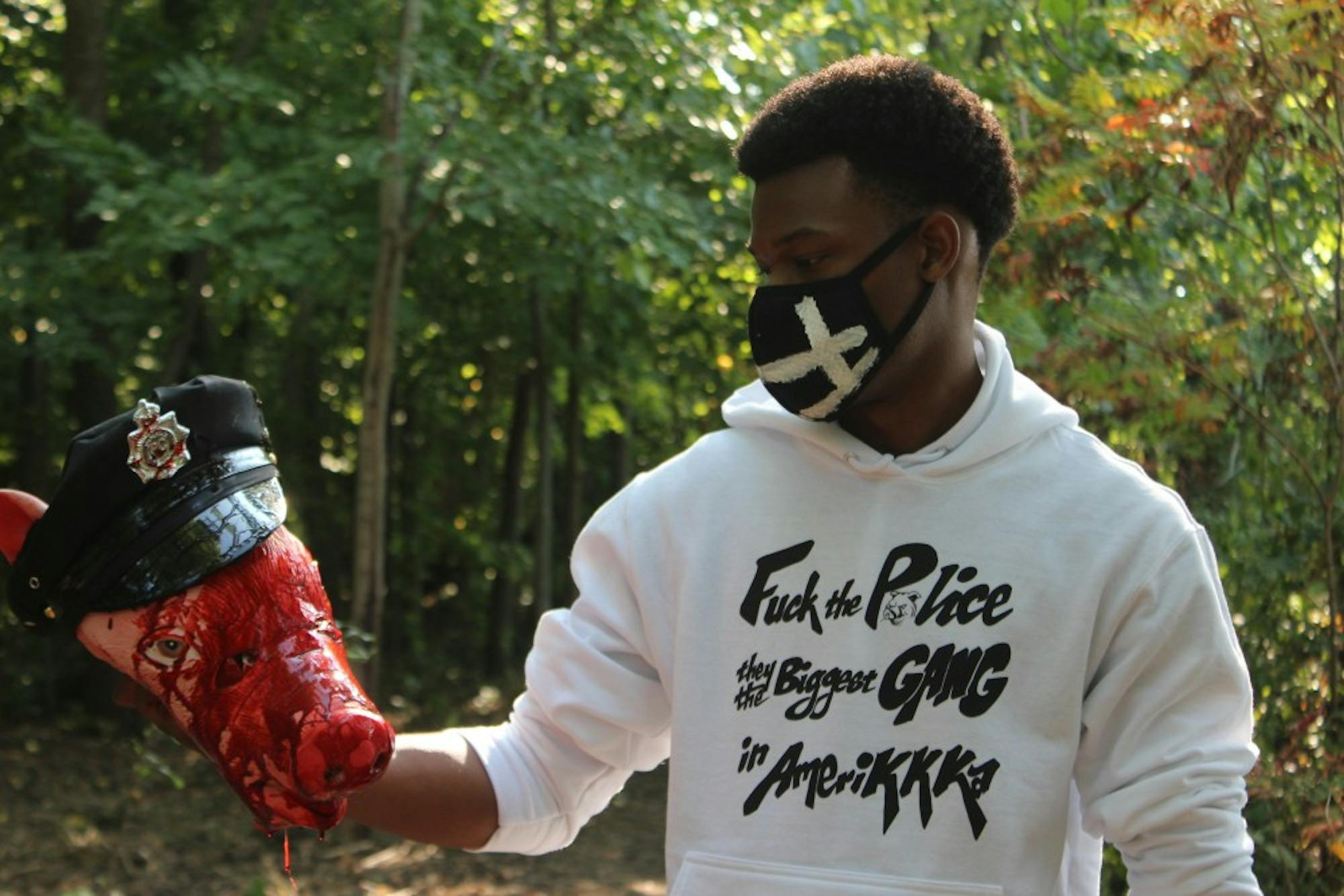 Eneale Pickett holds a beheaded police officer while promoting his new clothing line that focuses on police brutality in America.