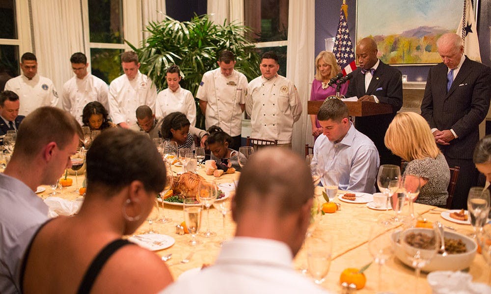 Vice President Joe Biden and Dr. Jill Biden bow their heads as Chaplain Barry Black gives the benediction during the fifth annual wounded warrior Thanksgiving dinner, at the Naval Observatory Residence, November 21, 2013. (Official White House Photo by David Lienemann)