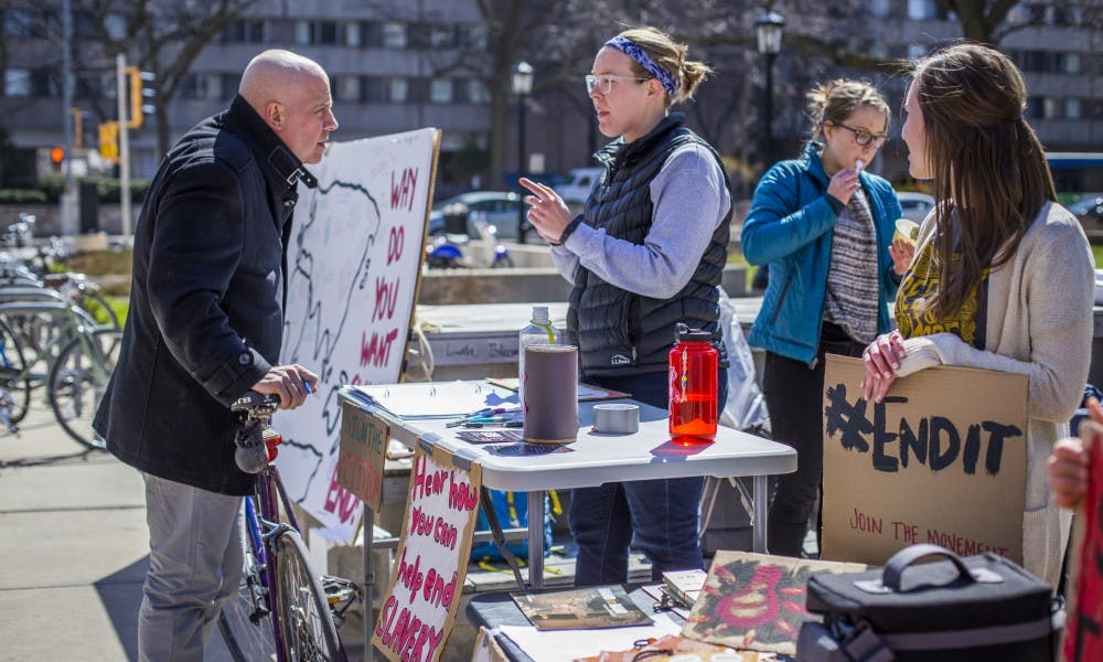 Students held signs on East Campus Mall Tuesday to spread awareness about modern-day slavery.
